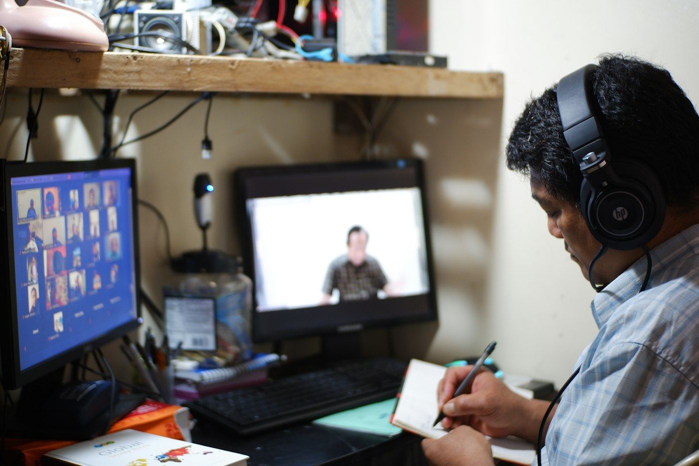 A working professional taking notes during an online class